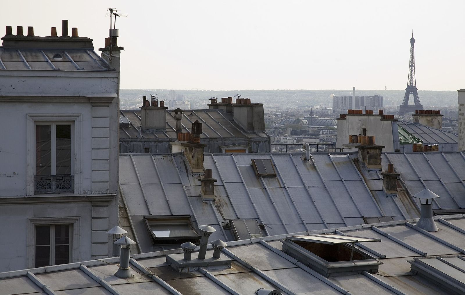 View across the terracotta rooftops of Montmartre with Sacré-Cœur in the distance